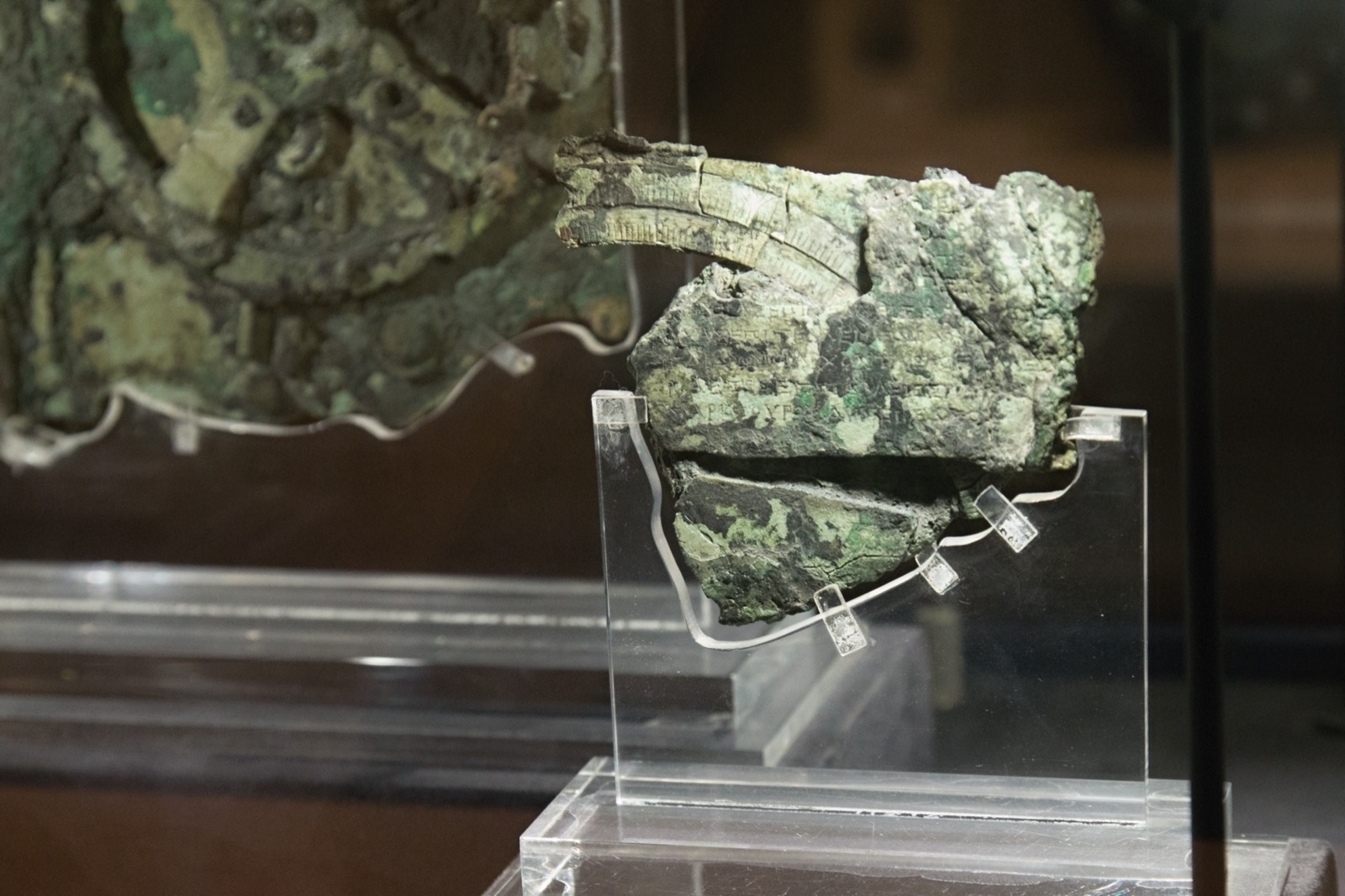 The main corroded bronze fragment of the Antikythera Mechanism, showing a large gear wheel, in the National Archaeological Museum in Athens.