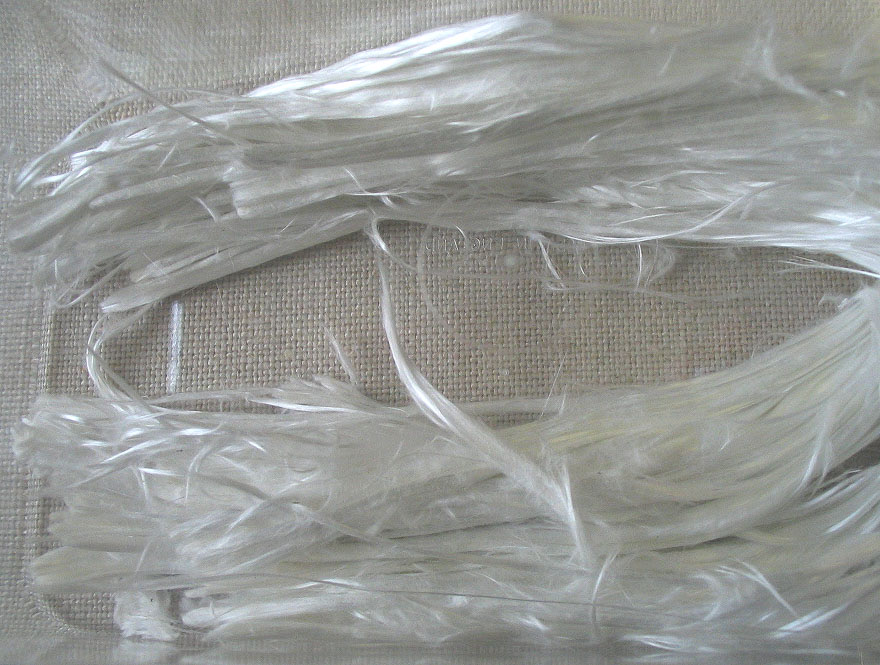 A magnified image of asbestos fibers, showing their fine, needle-like structure.