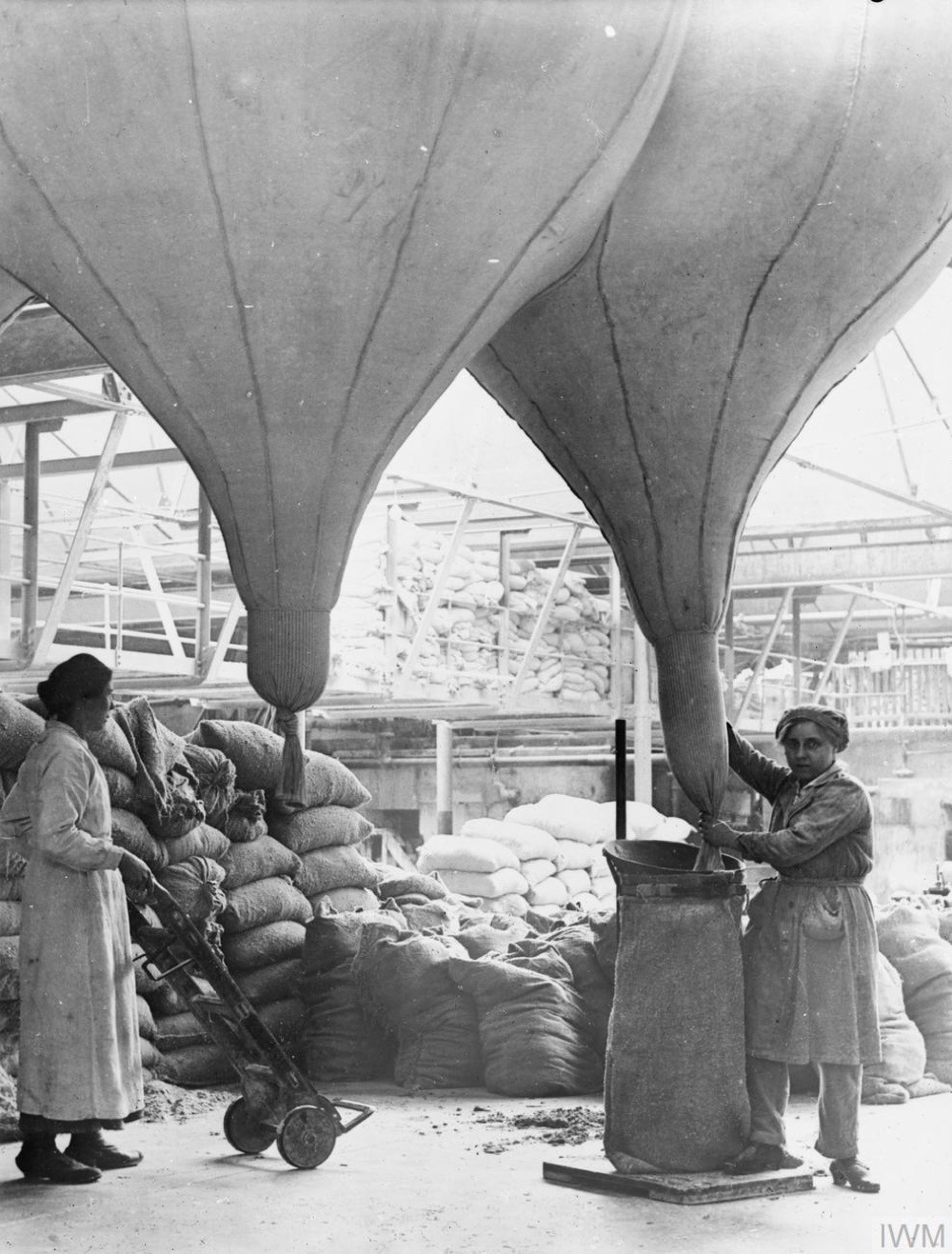 Women working in a Lancashire asbestos factory in the early twentieth century, surrounded by asbestos material.