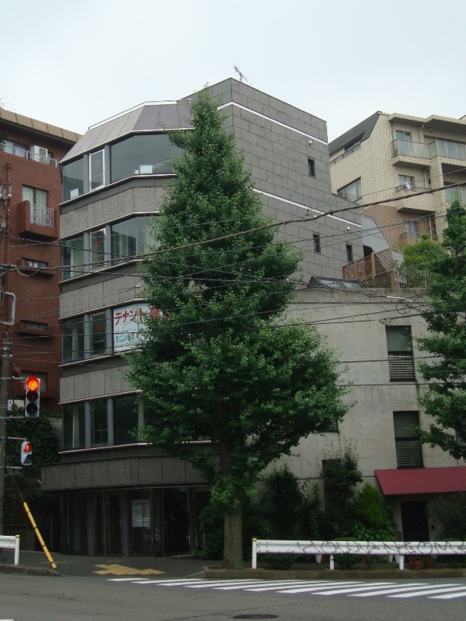 A former Aum Shinrikyo headquarters building in Tokyo, photographed in 2011 — a four-storey office building with weathered concrete exterior.