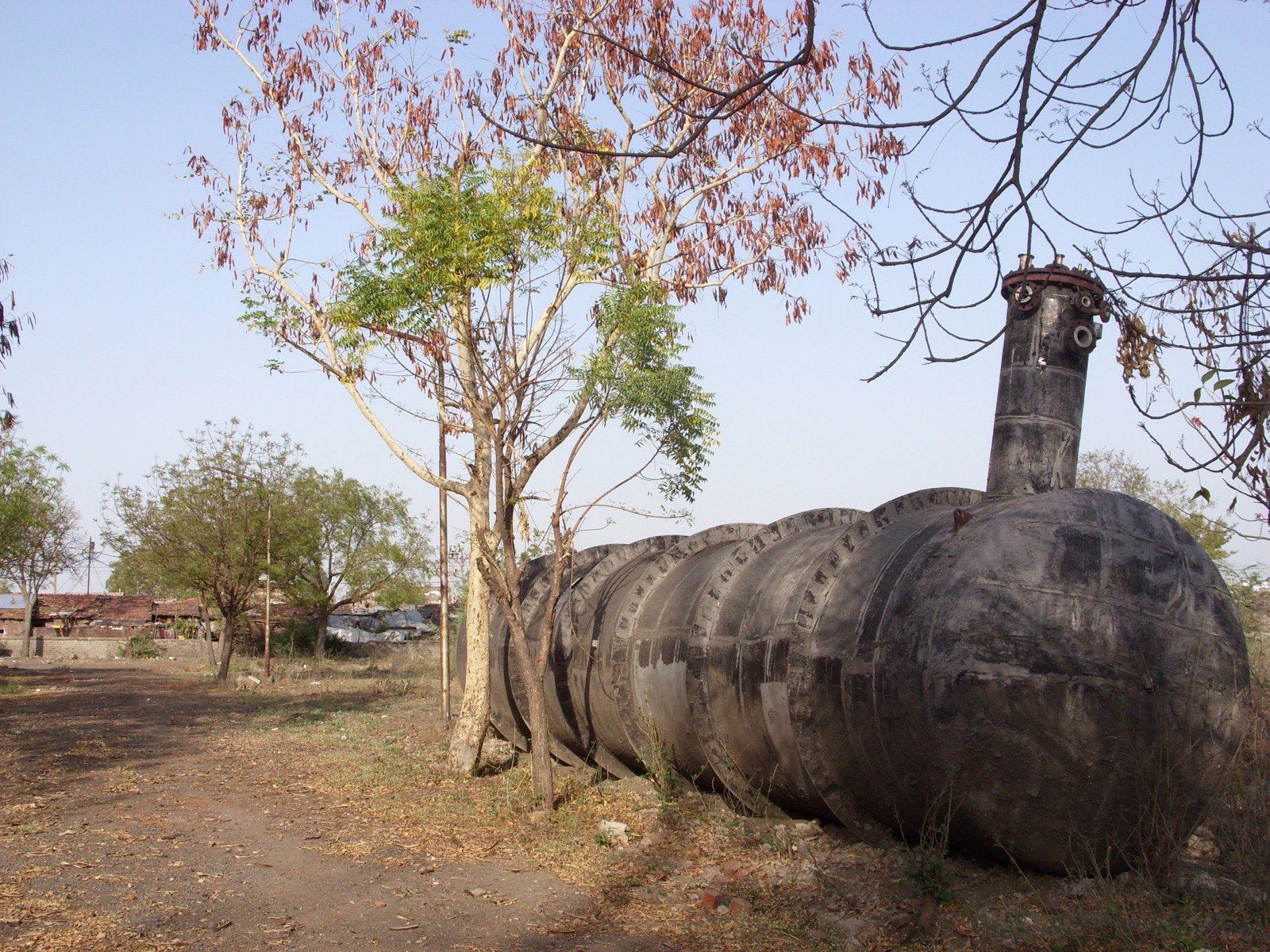 Ruins of one of the Union Carbide plant buildings in Bhopal, photographed in the 2000s — abandoned concrete structures and rusted tanks.
