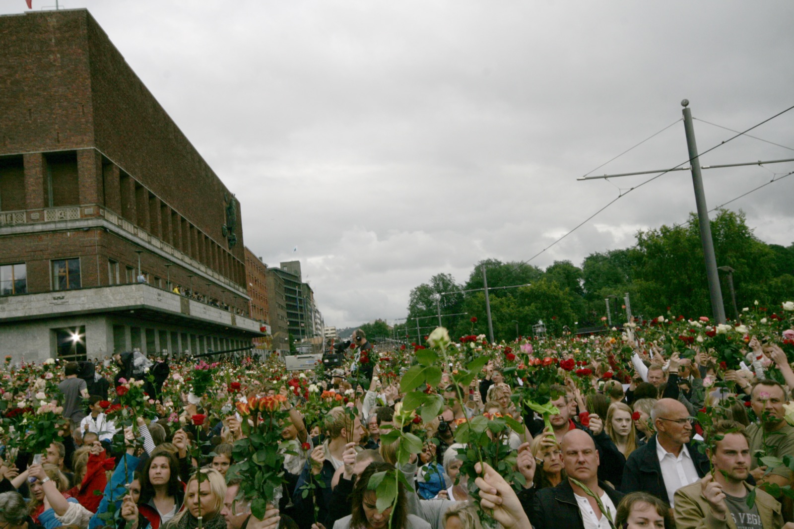 A large crowd of people holding roses at the 2011 flower march in Oslo, gathered in tribute after the attacks.