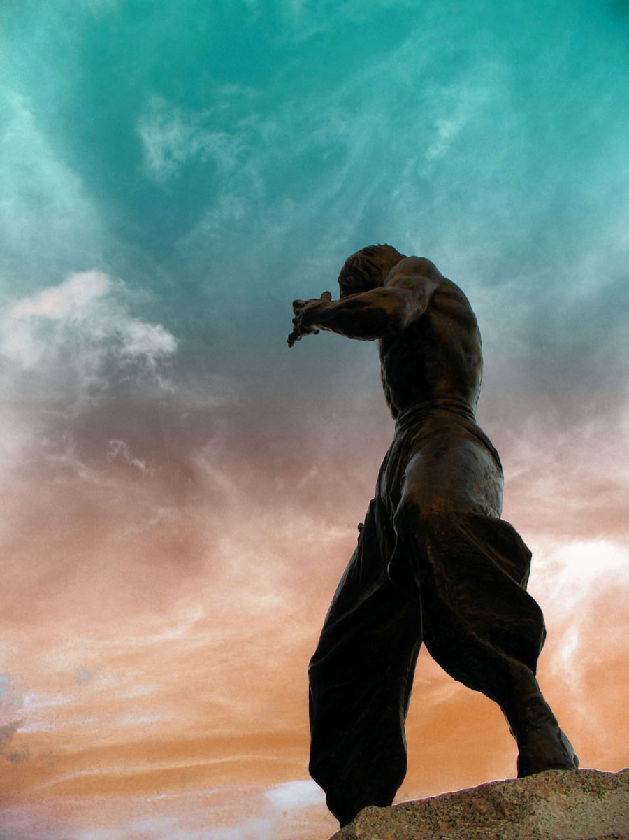 A low-angle view of the dynamic Bruce Lee statue in Hong Kong.
