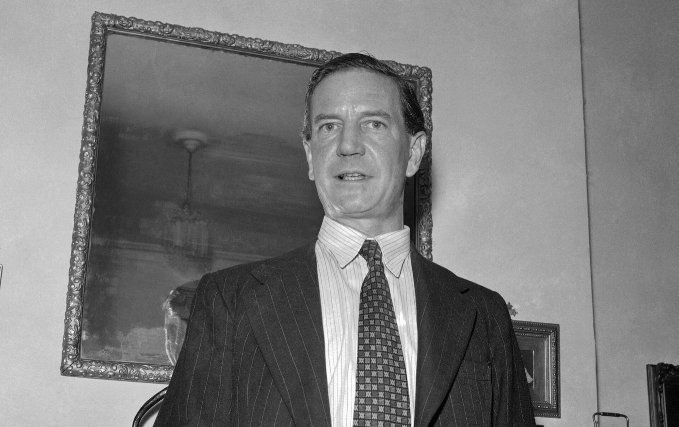 Kim Philby in 1955, a composed middle-aged man in a suit, photographed at a press conference.