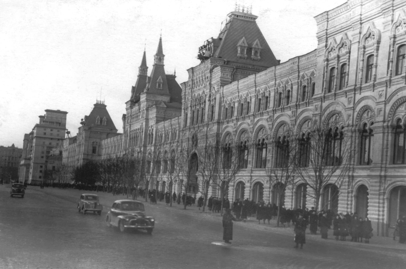 A view of GUM department store on Red Square in Moscow in 1953, with period crowds and architecture.