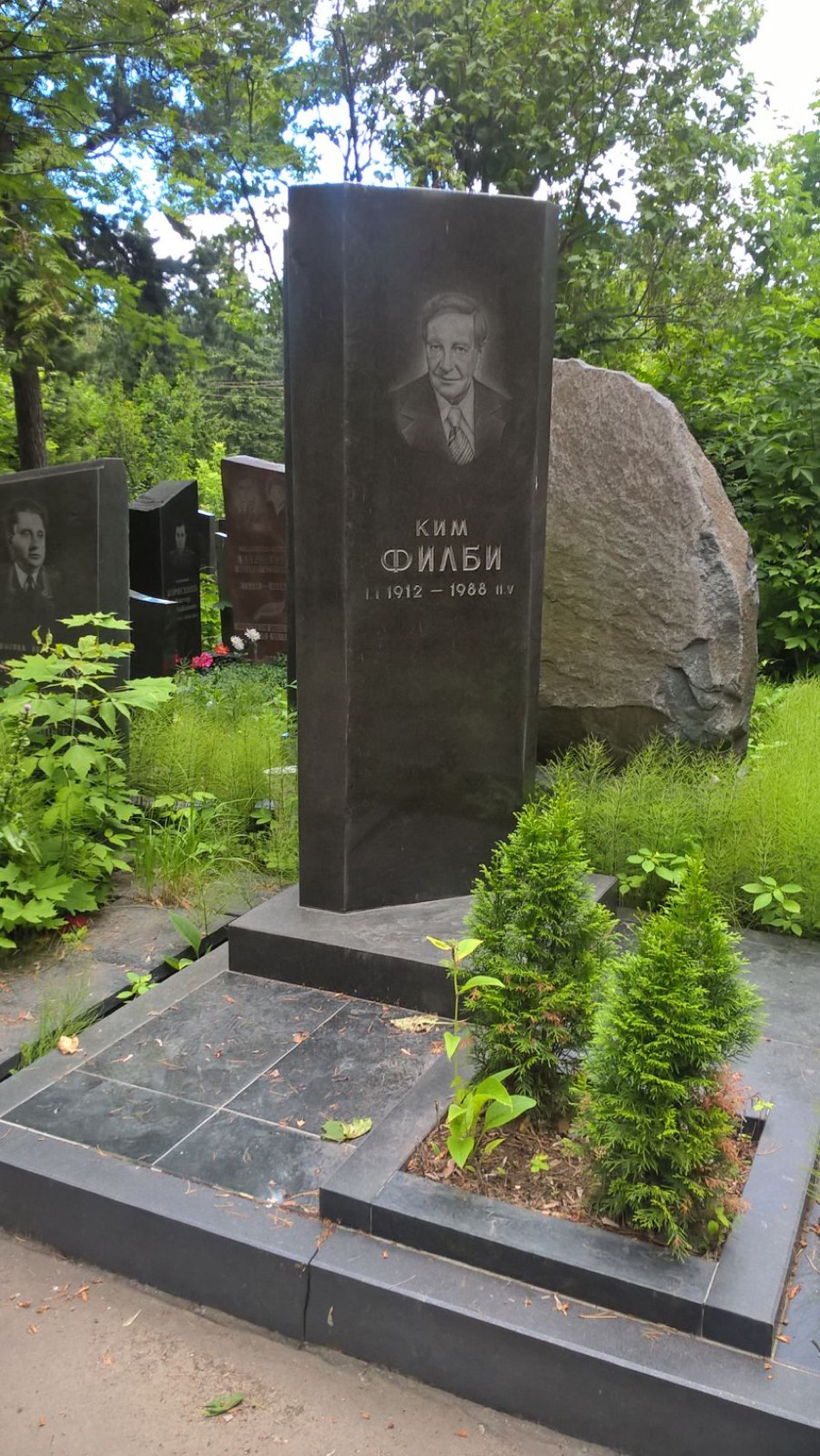 The grave of Kim Philby in Moscow, a dark headstone bearing his name in Cyrillic.