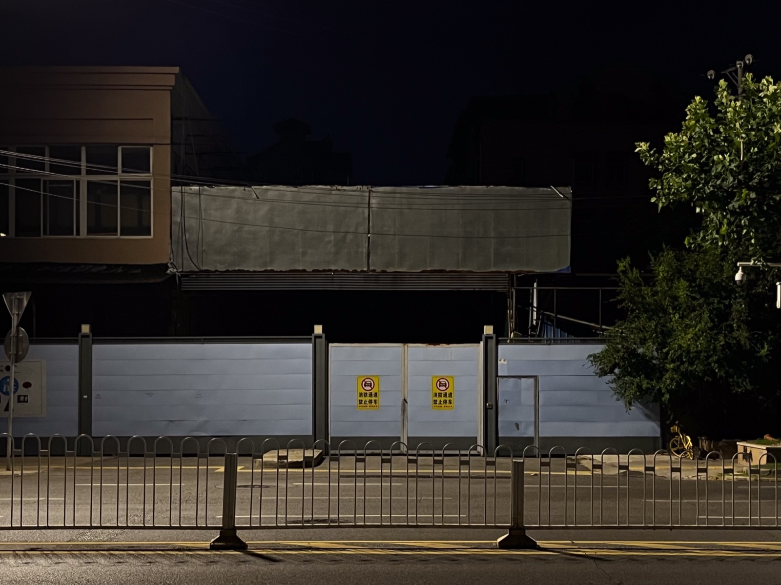 The Huanan Seafood Wholesale Market in Wuhan, photographed from outside the fence in 2025. The buildings are visible behind a security perimeter.
