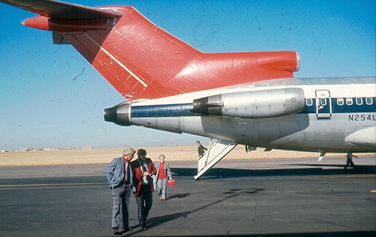 The rear of a Northwest Boeing 727 with its ventral airstair lowered — a set of steps folding down from beneath the tail of the aircraft to the ground, between the rear-mounted engines.