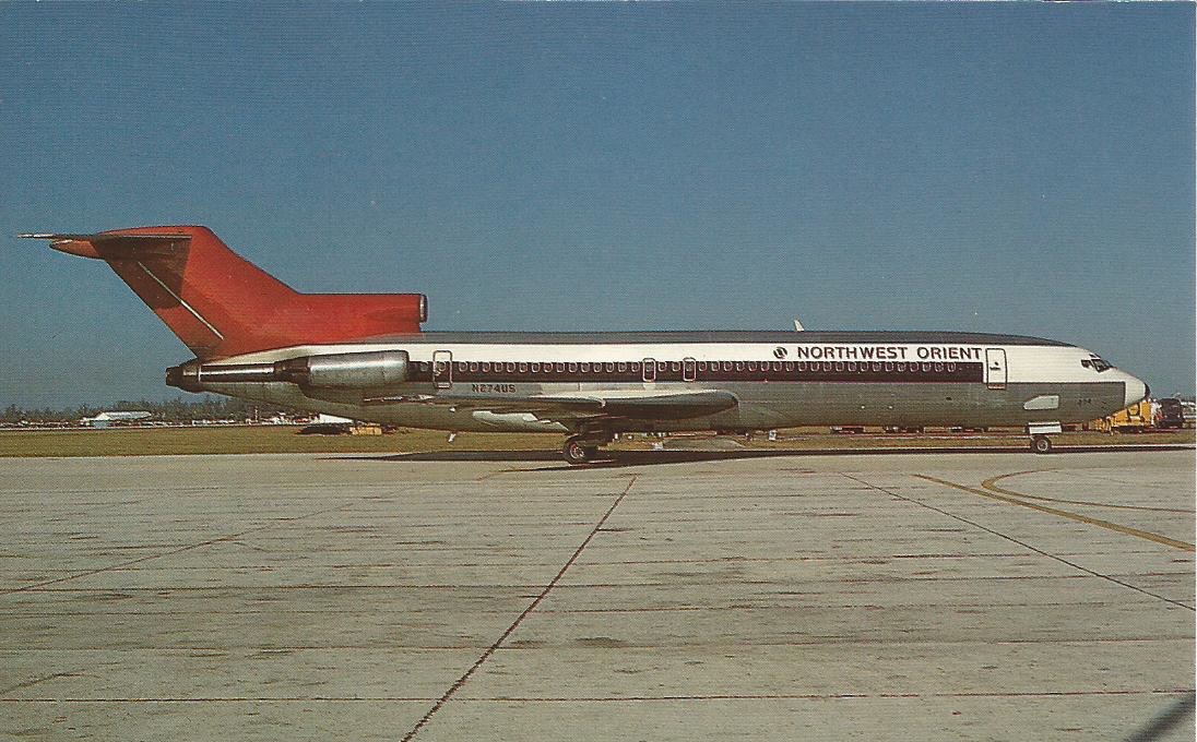 A Northwest Orient Airlines Boeing 727 on an airport apron — a narrow-bodied three-engined jet in silver with a white roof and the airline's distinctive red tail fin, photographed side-on under a blue sky.
