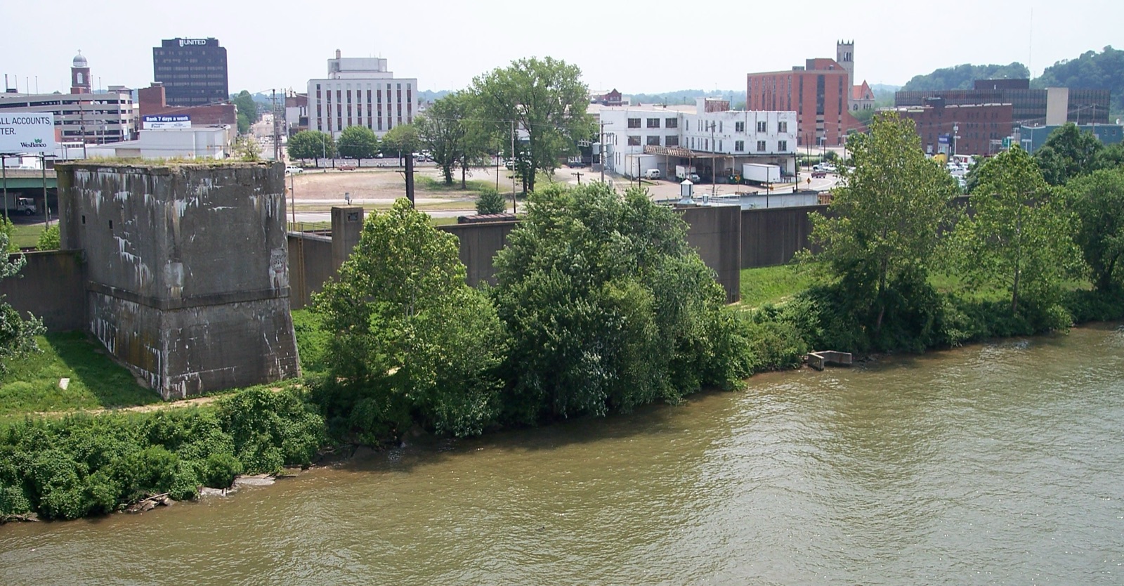 The skyline of Parkersburg, West Virginia, along the Ohio River — a small city of red-brick buildings and church spires, with the river curving in the foreground.