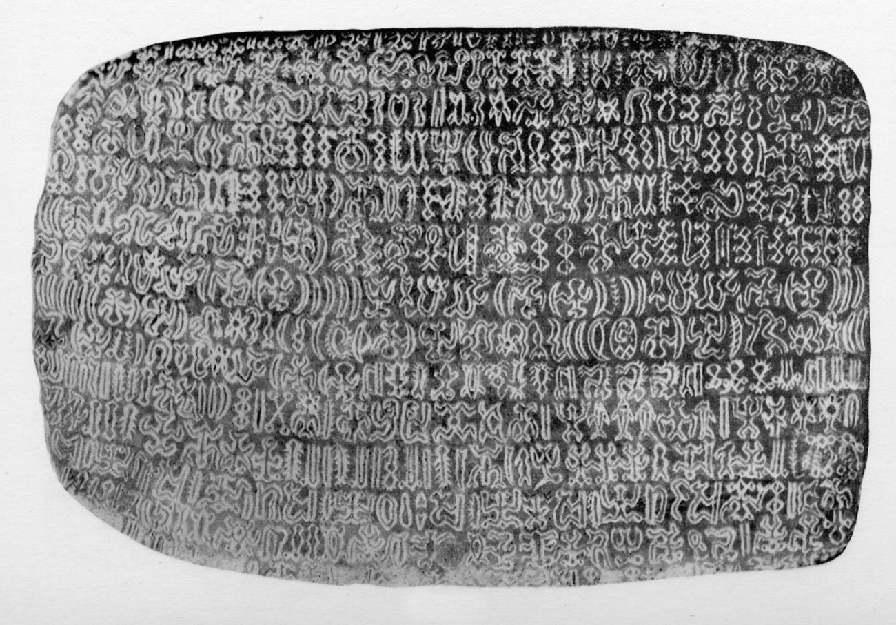 A rongorongo tablet showing rows of small incised glyphs of figures and abstract shapes.