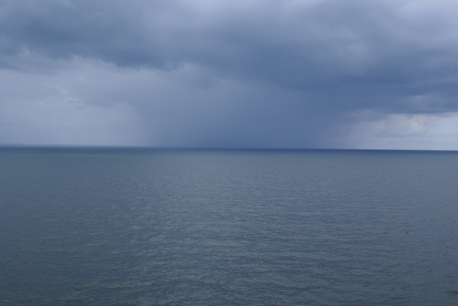 A grey, storm-tossed Baltic Sea under a heavy overcast sky, white-capped waves stretching to the horizon.