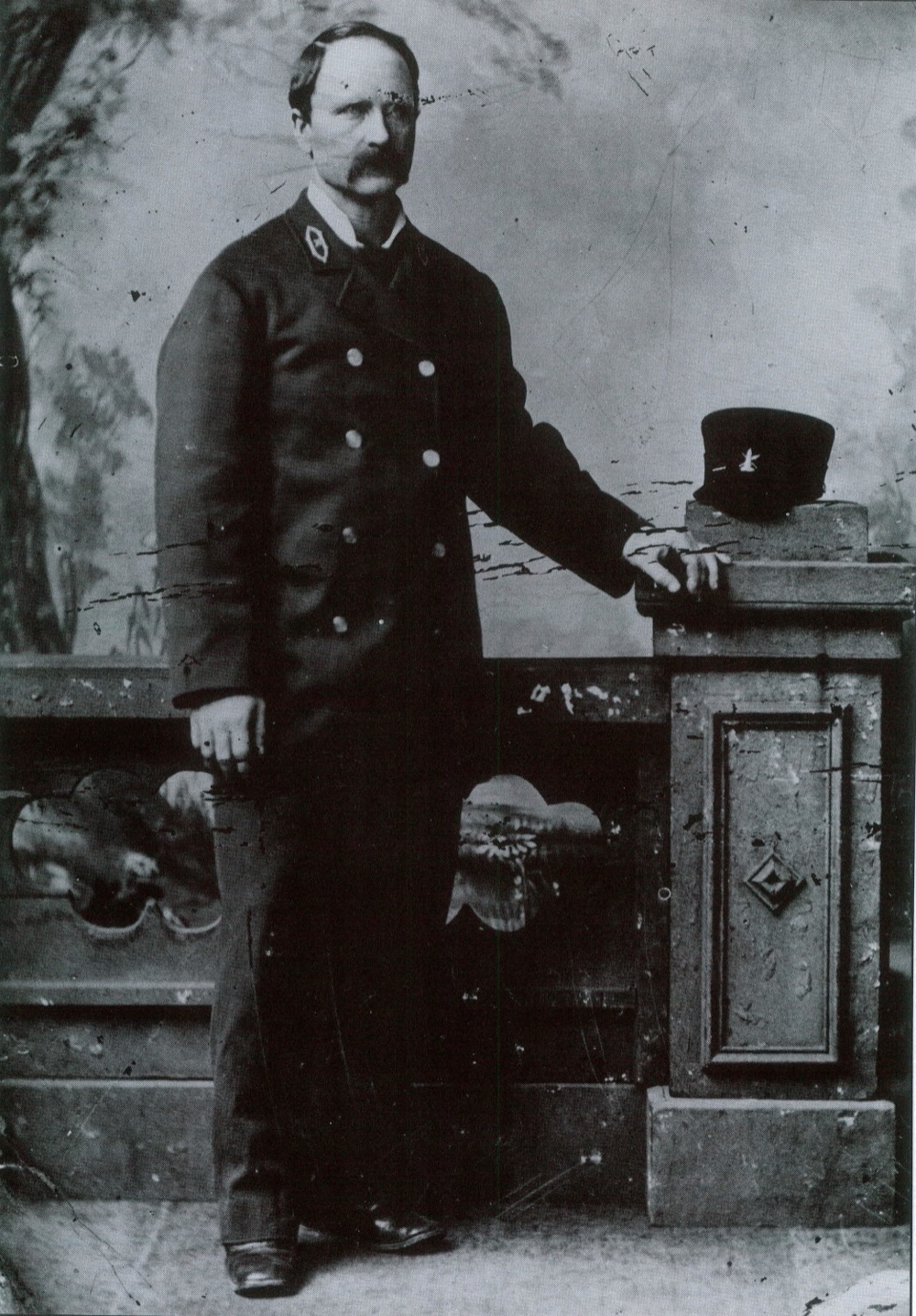 A historical photograph of a lighthouse keeper in uniform, representing the keepers of the era.