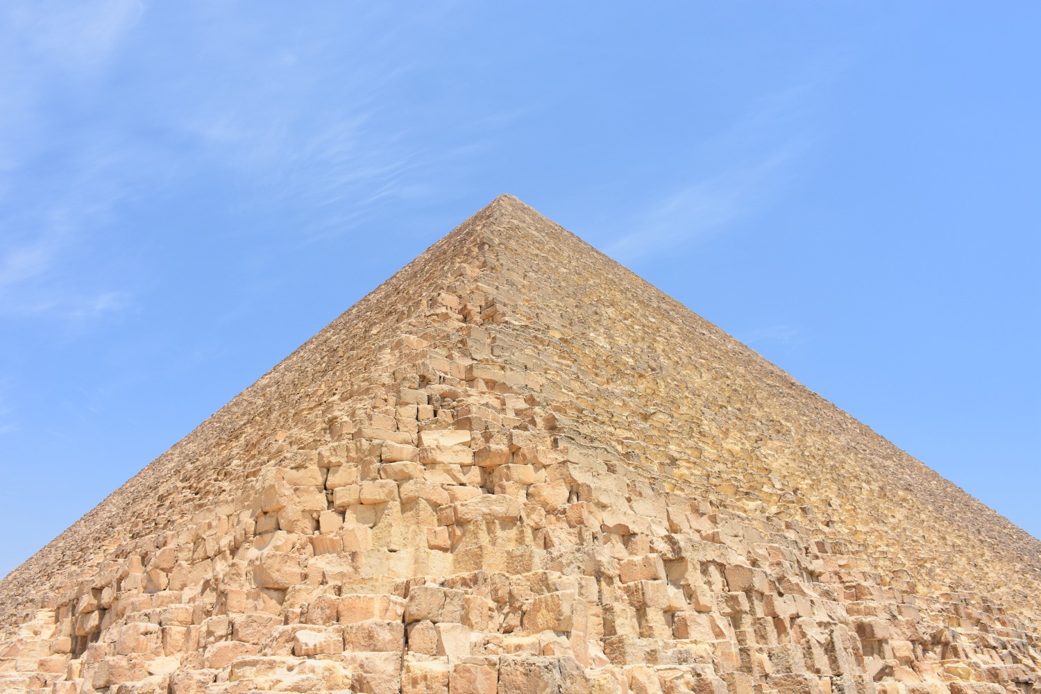 The Great Pyramid of Giza seen from its southeast corner, its stepped courses of limestone blocks rising against a clear sky.
