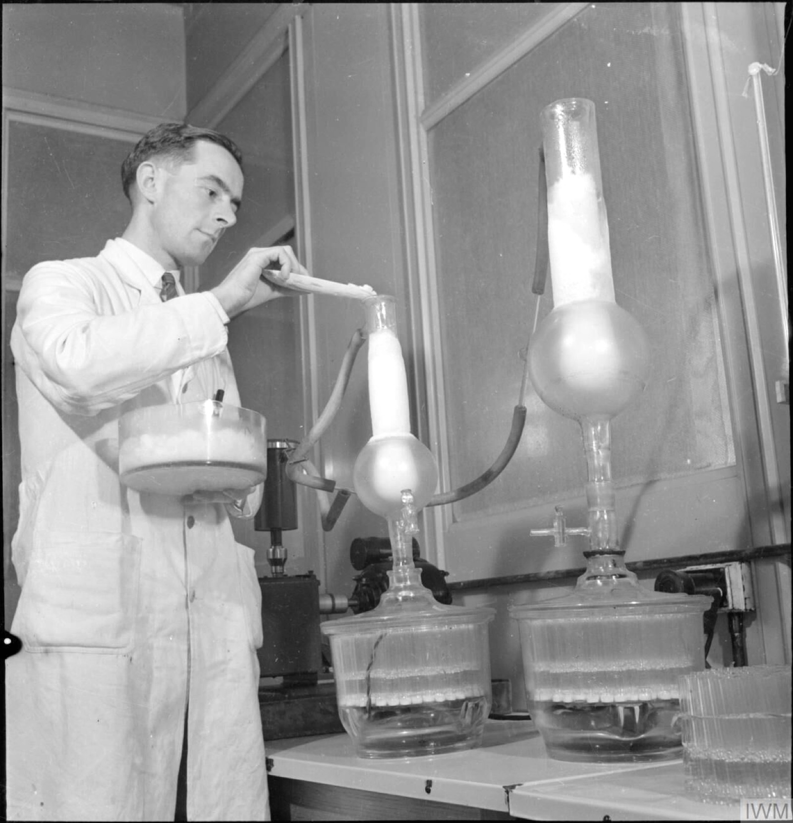 A 1943 photograph related to penicillin production, showing glass vessels and apparatus used in the early manufacture of the drug.