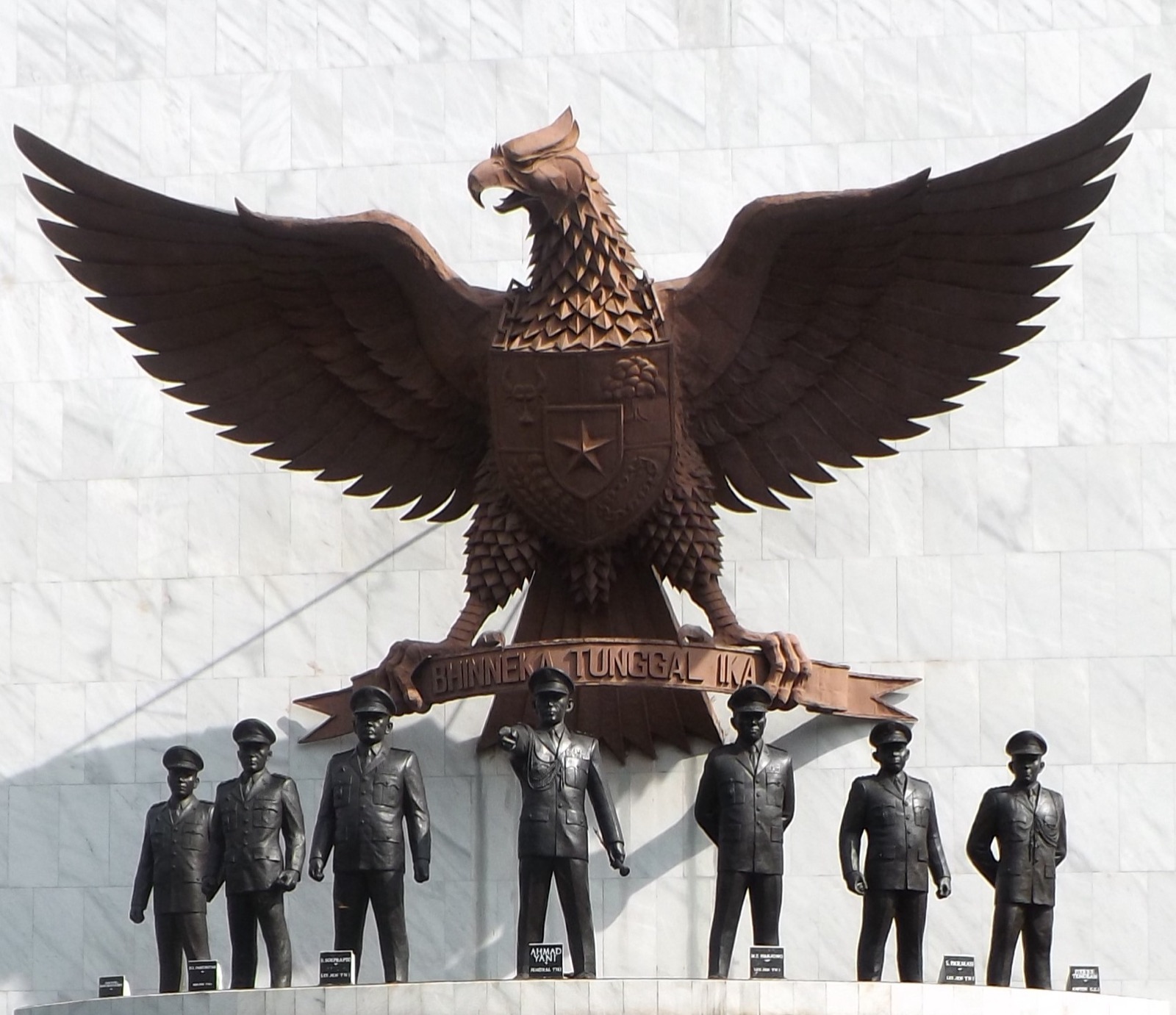 The Pancasila Sakti Monument at Lubang Buaya — bronze statues of seven Indonesian military officers on a stone platform, set in a memorial garden.