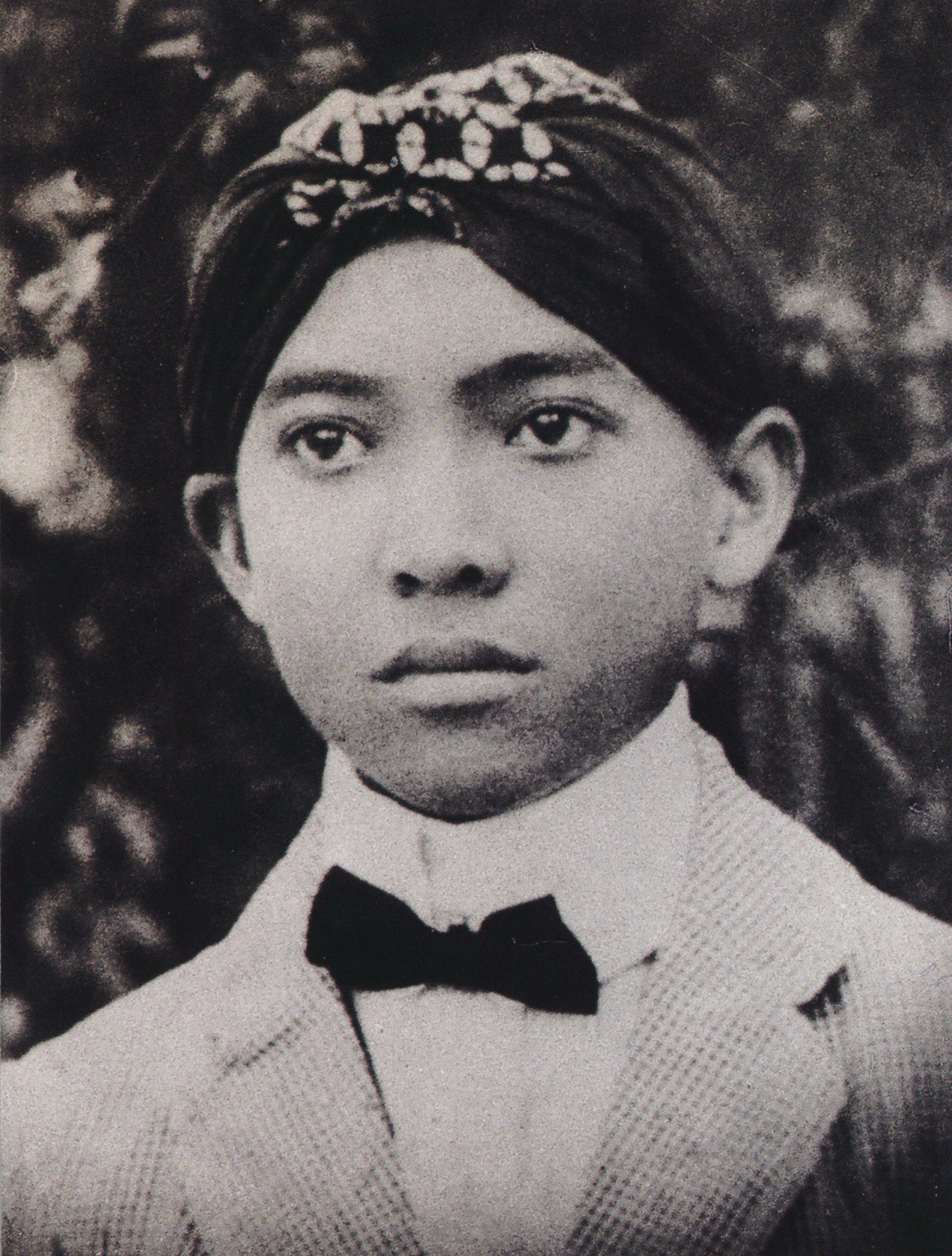 Sukarno, the first President of Indonesia, photographed in a peci hat and dark jacket — official portrait style.