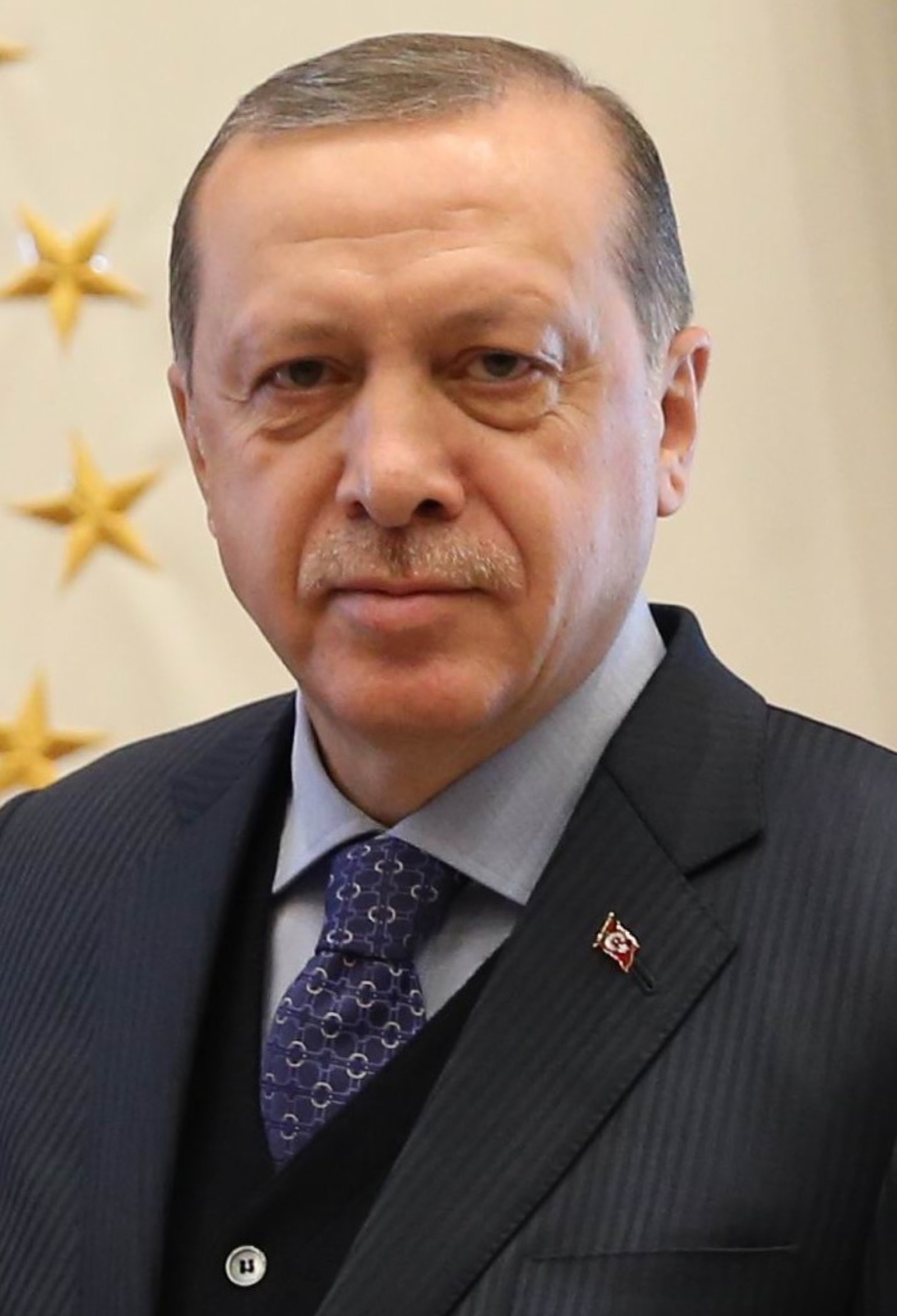Recep Tayyip Erdoğan photographed in 2017 — wearing a dark suit, looking past the camera.
