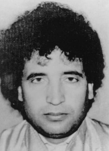Abdelbaset al-Megrahi in an early-1990s photograph — a middle-aged man with dark hair and beard, wearing a dark jacket, photographed in formal portrait pose.
