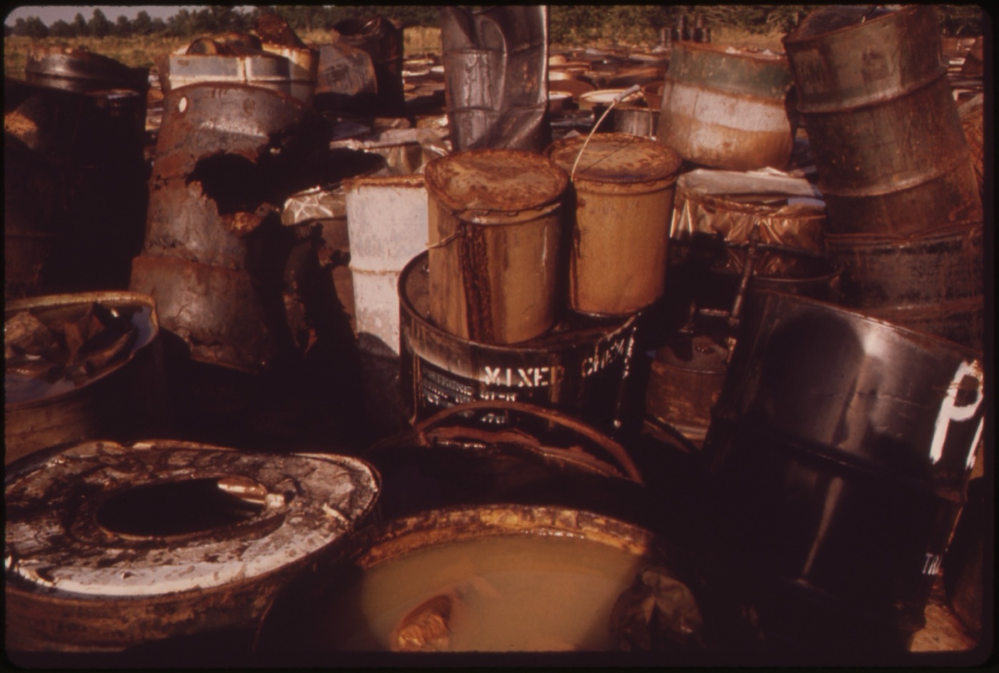 Thousands of drums of hazardous industrial waste stored in a field, of the kind buried at chemical dump sites.