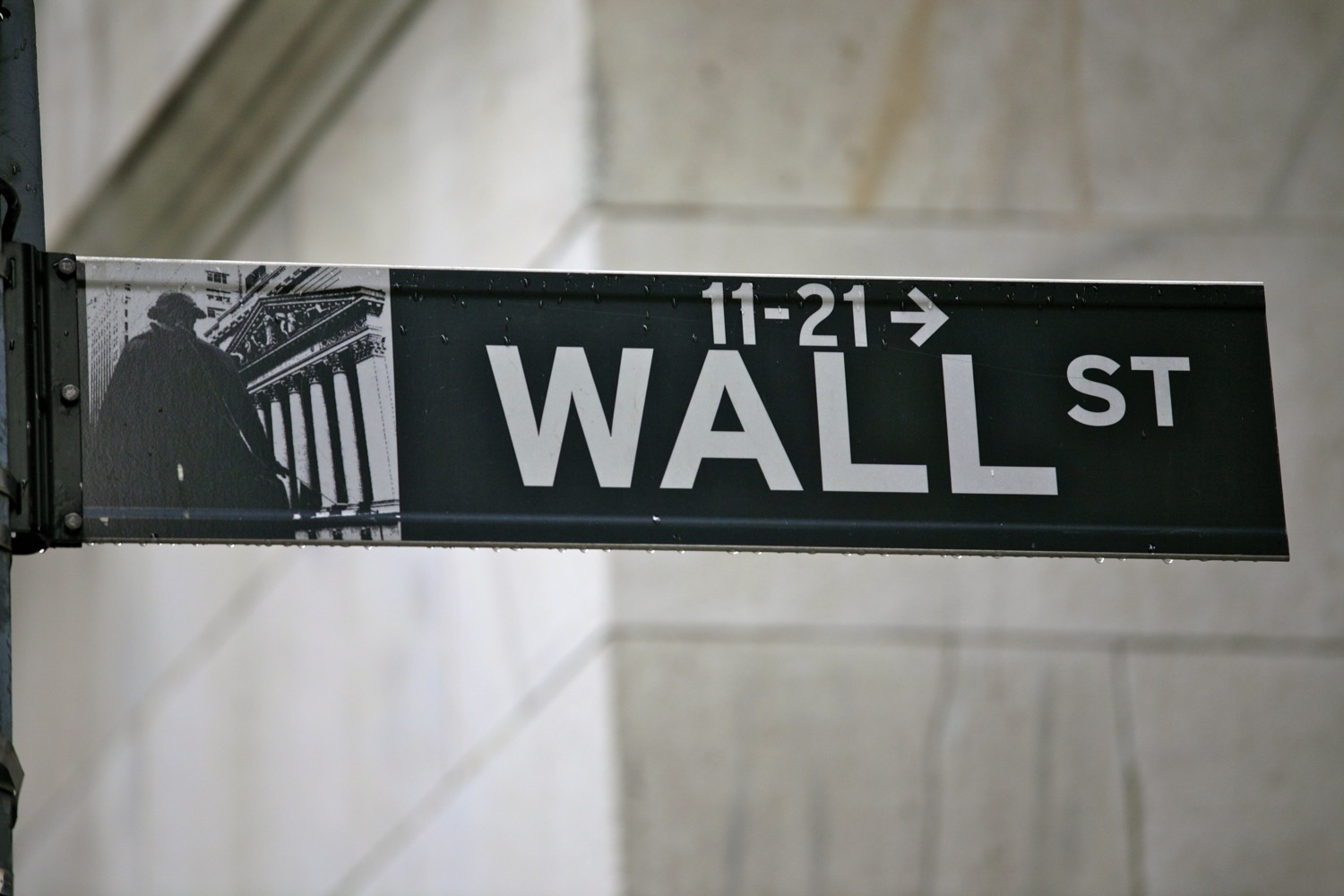 The iconic 'Wall Street' street sign in Lower Manhattan, marking the financial district.