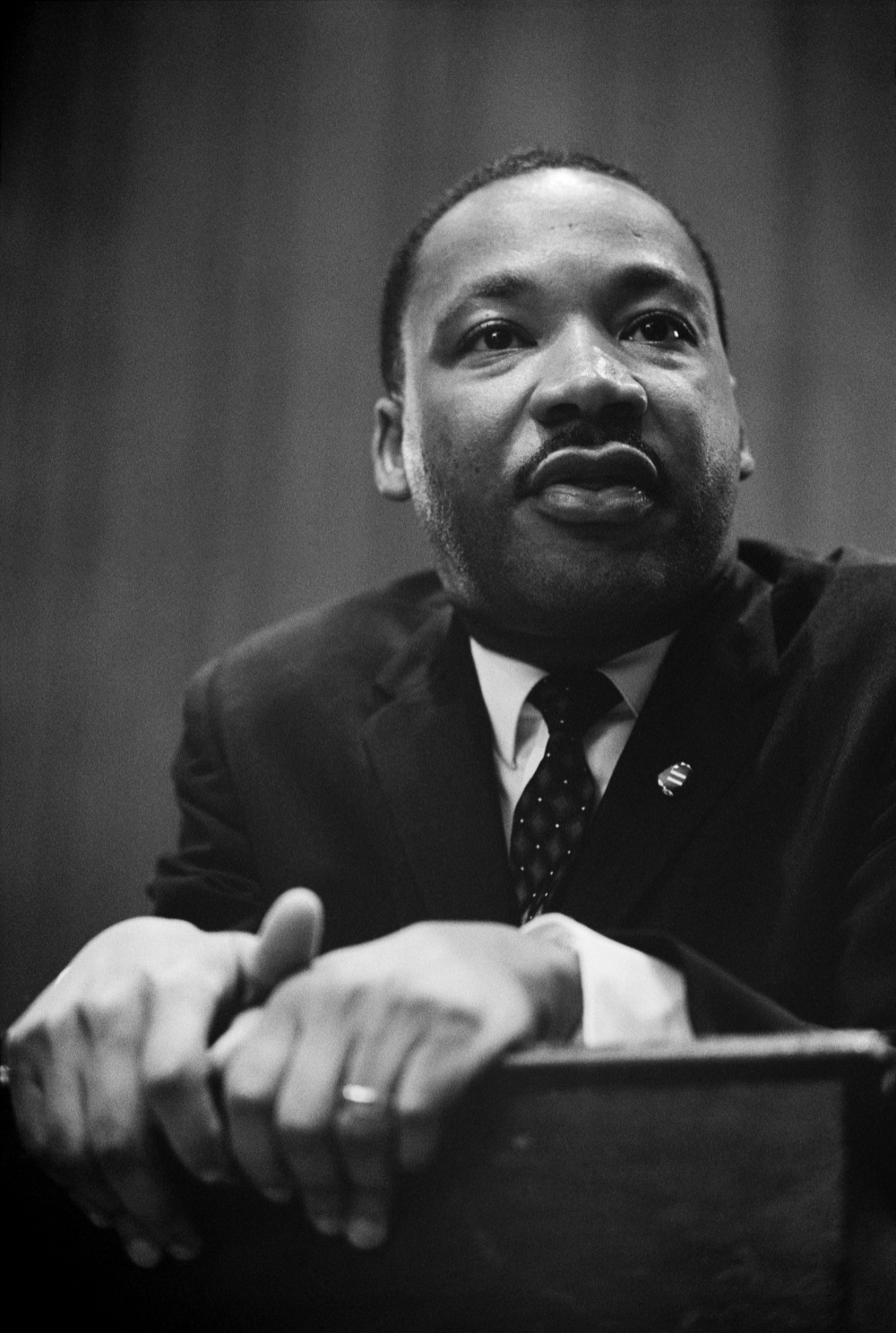 A portrait of Martin Luther King Jr. at a press conference.