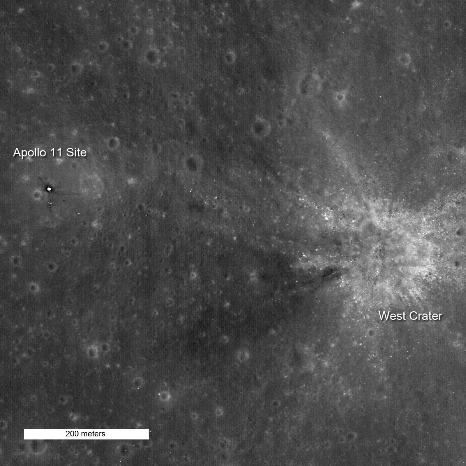 The Apollo 11 landing site photographed from lunar orbit by the NASA Lunar Reconnaissance Orbiter Camera in 2011. The lunar module descent stage, footprint trails, and surface experiment packages are visible against the cratered grey lunar surface.