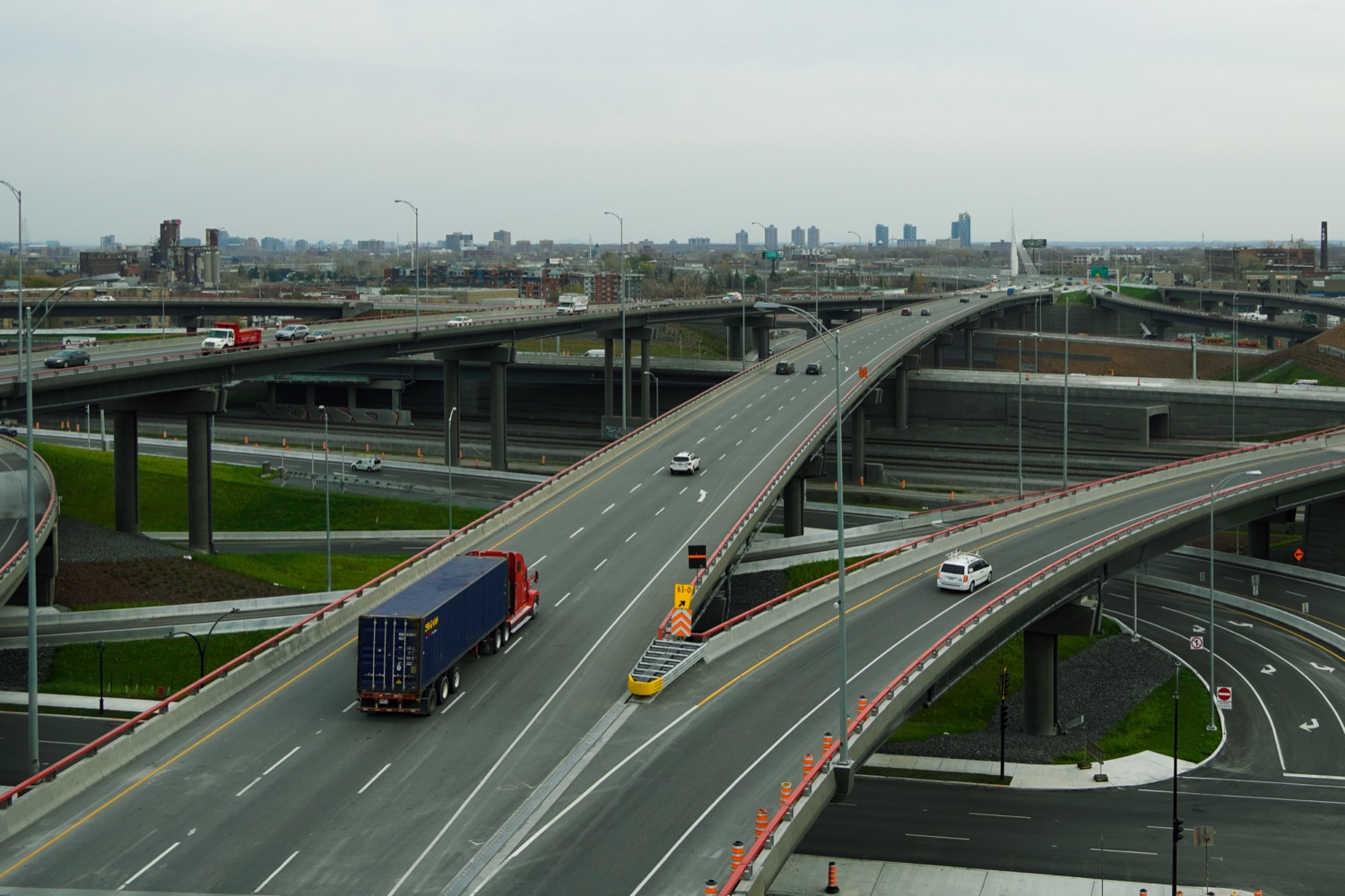 A semi-truck driving on a highway bridge, a large articulated lorry of the kind used for long-haul freight.