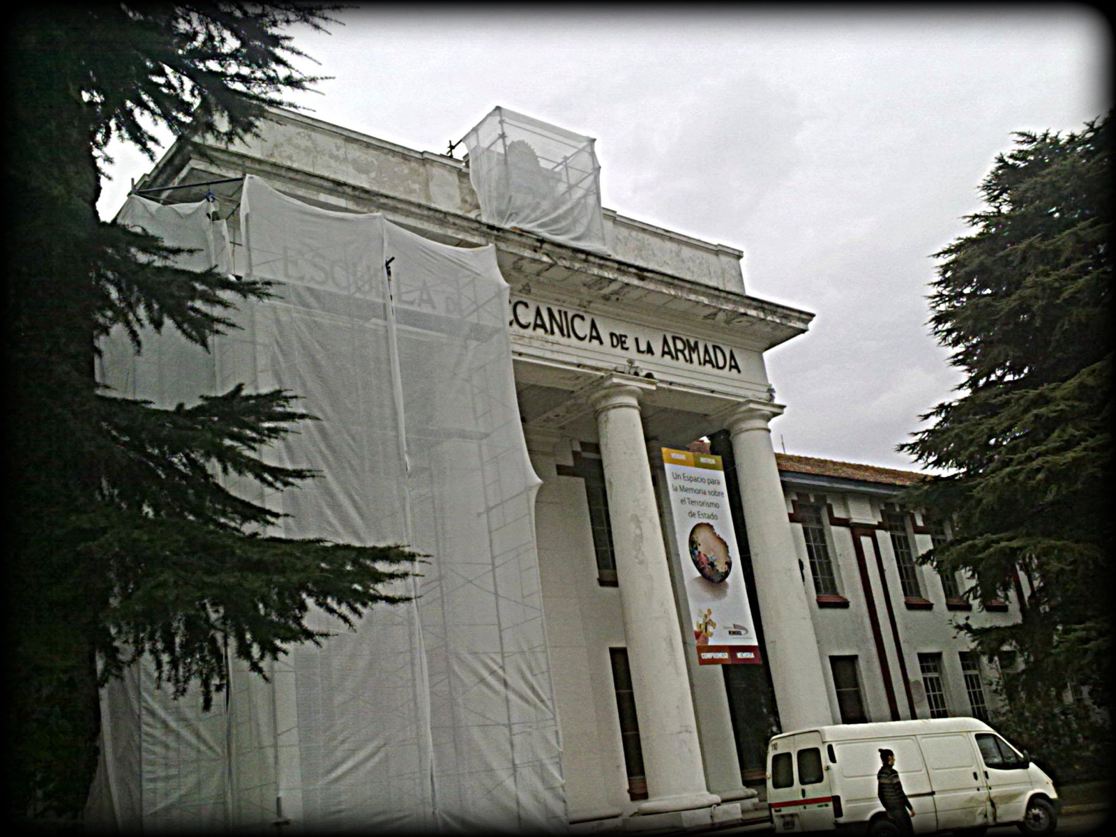 The Casino de Oficiales building of the former Escuela Superior de Mecánica de la Armada (ESMA), Buenos Aires — a four-storey early-20th-century neoclassical building with white stucco facade and large grid of windows, photographed from the avenue.