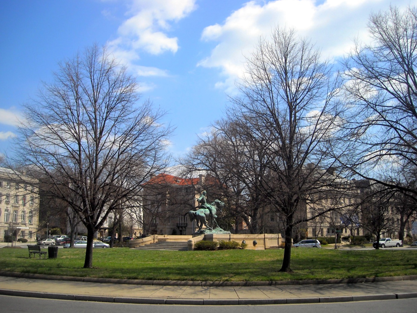 Sheridan Circle, Washington D.C. — an oval traffic circle with a central monument to Civil War general Phil Sheridan on horseback, surrounded by stately early-20th-century embassy buildings and tall mature trees.