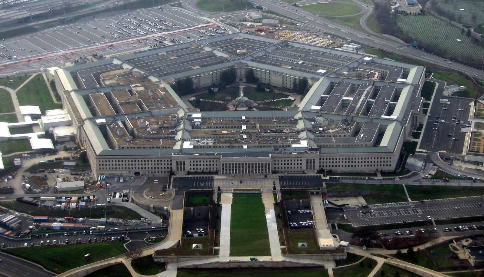 The Pentagon in Arlington, Virginia, photographed from the air on a clear winter morning — a five-sided concrete and limestone building of five concentric rings around an open central courtyard.