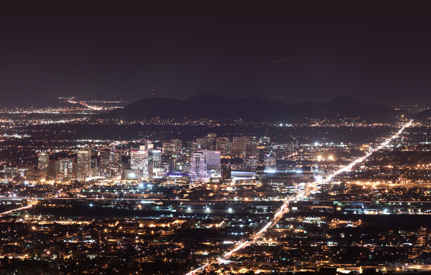 The skyline of downtown Phoenix, Arizona, at night, lit against the dark sky.