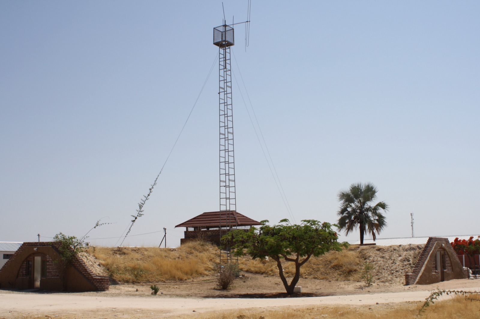 A weathered, abandoned military base building of the former South African Defence Force at Outapi in northern Namibia, low concrete structures under a wide, dry sky.