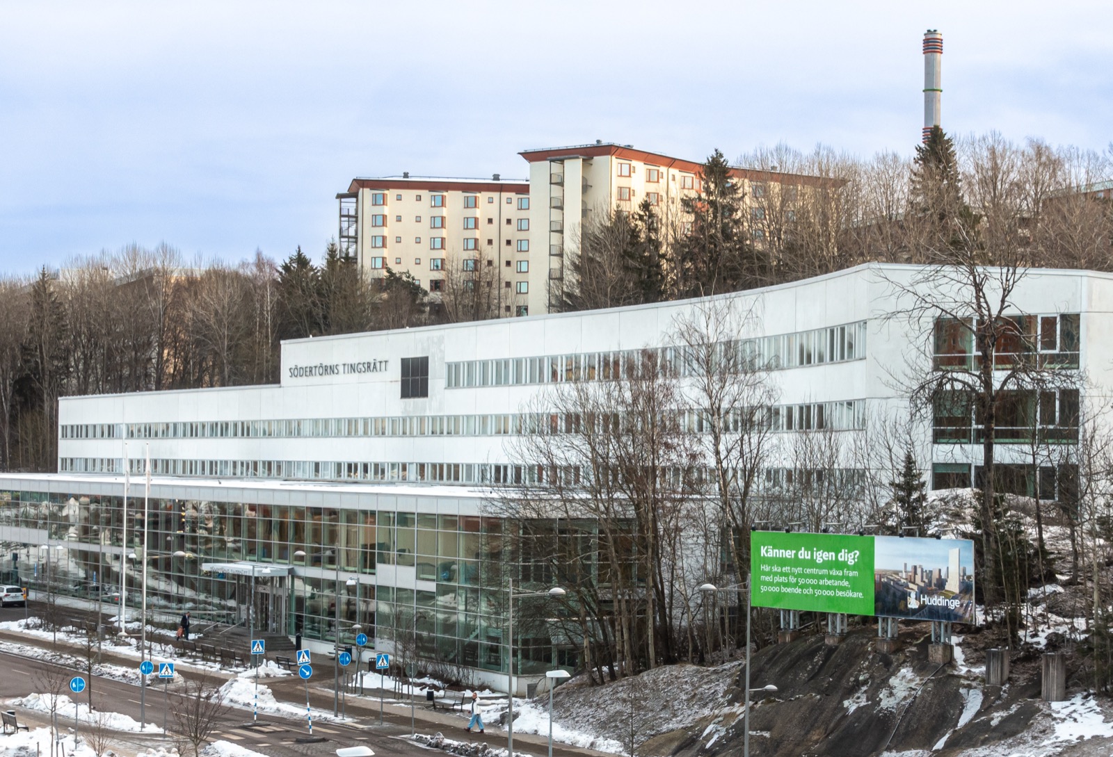 The exterior of a modern Swedish district court building, a clean low structure with the Swedish coat of arms.
