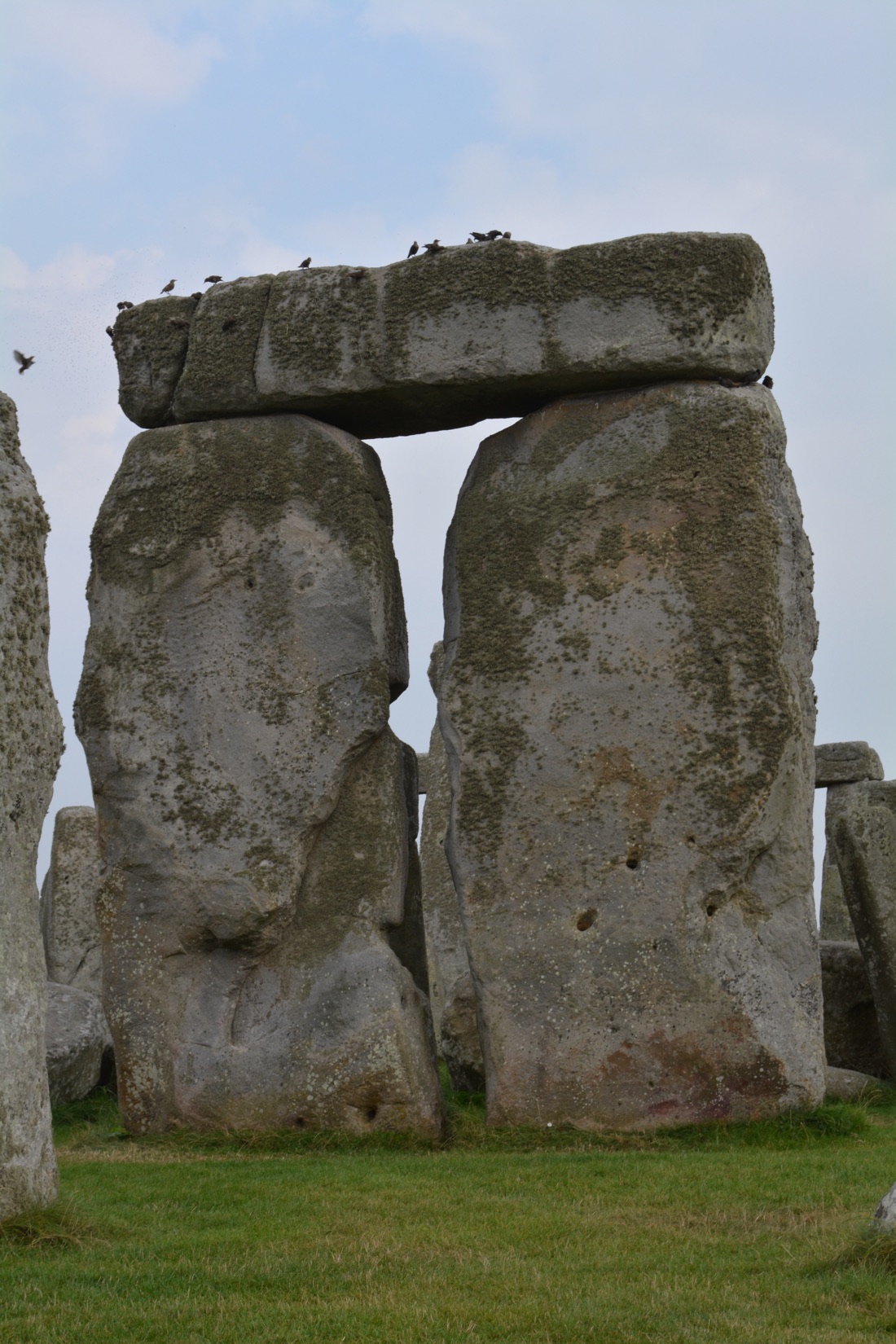 A close view of one of the great sarsen trilithons of Stonehenge, two massive uprights bearing a horizontal lintel.