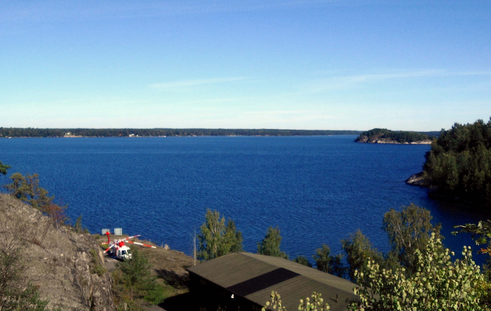 A view across Hårsfjärden bay near Stockholm, calm water bordered by low forested shores under a grey sky.