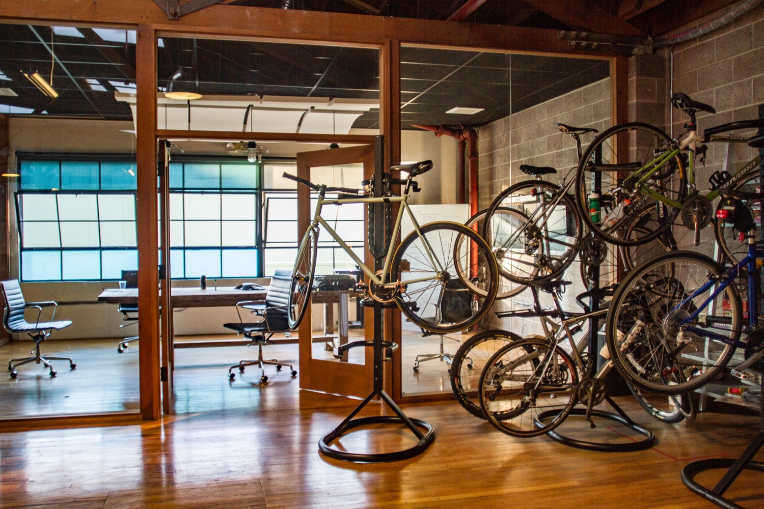 The interior of a San Francisco startup office with open-plan desks and indoor bicycle parking, in the casual style of a tech company.