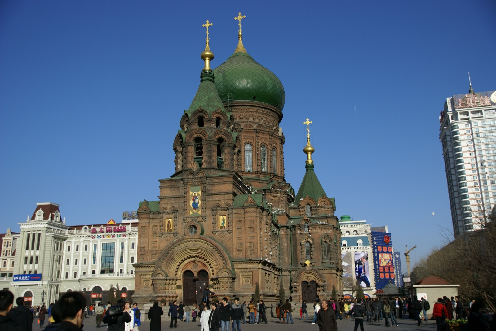St. Sophia Cathedral in Harbin, a 19th-century Russian Orthodox church with green-painted onion domes against a blue sky.