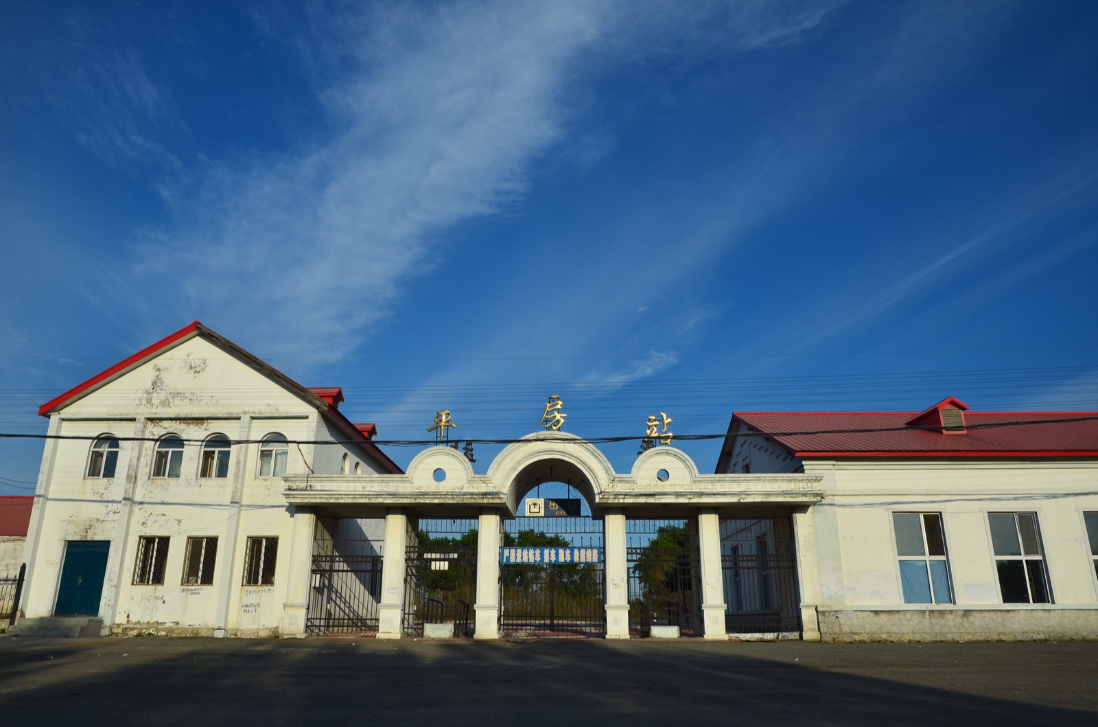 The Pingfang Railway Station, a small Chinese railway facility — concrete platform, simple station building, partially modern signage.