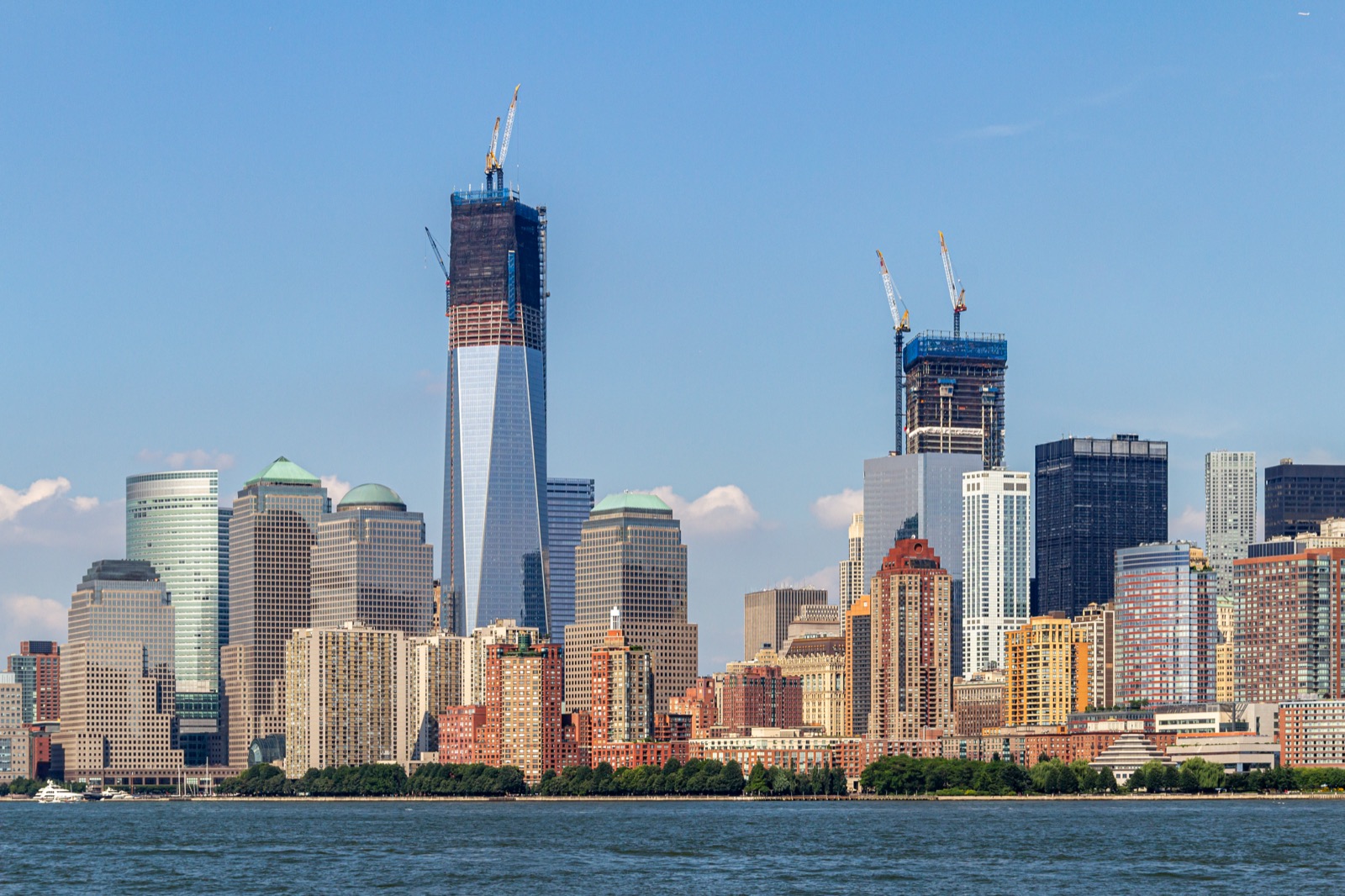 The Manhattan skyline in New York City, a dense cluster of office towers and skyscrapers under a clear sky.