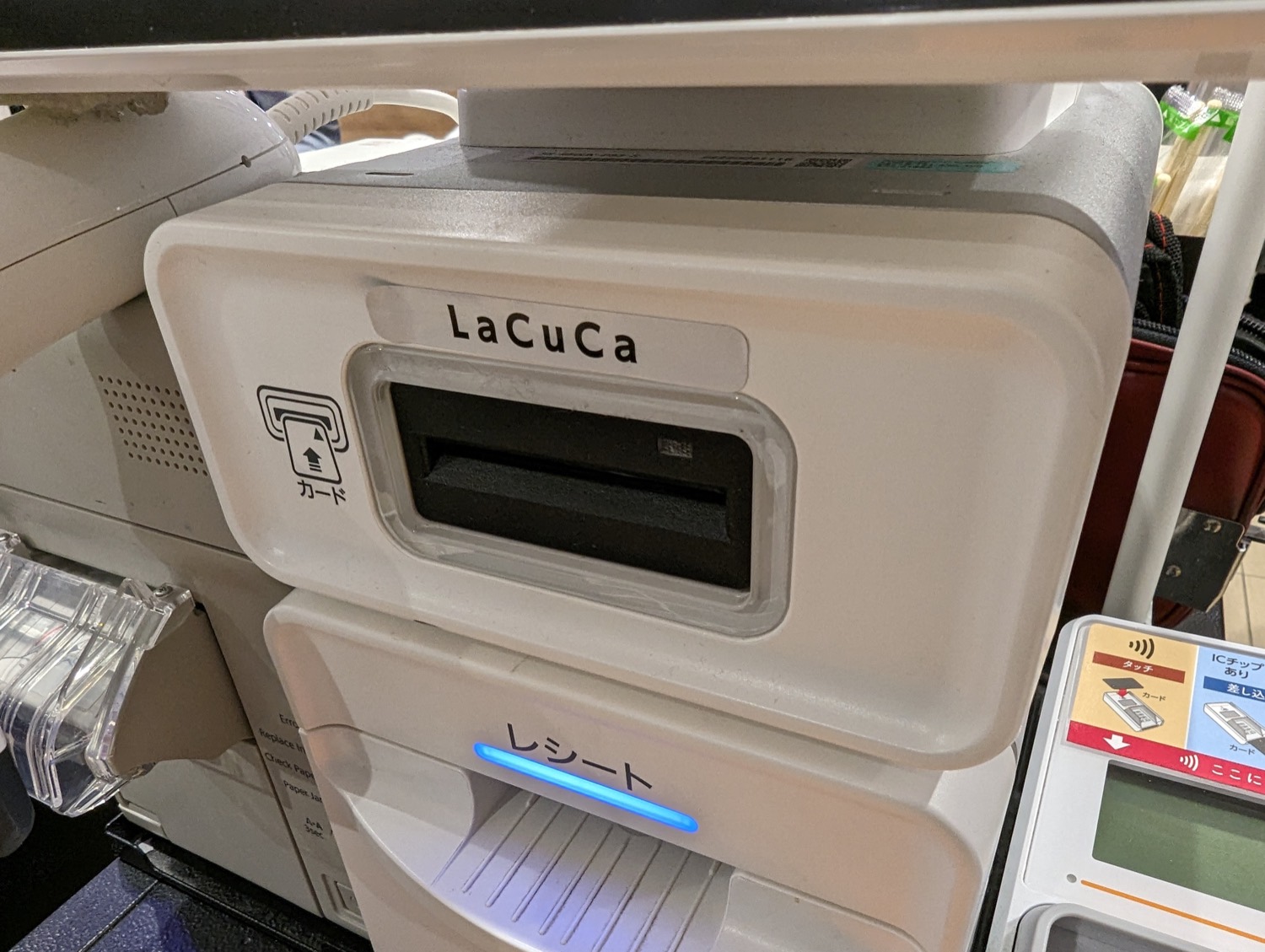 A card payment terminal at a supermarket checkout, with a customer's card being read.